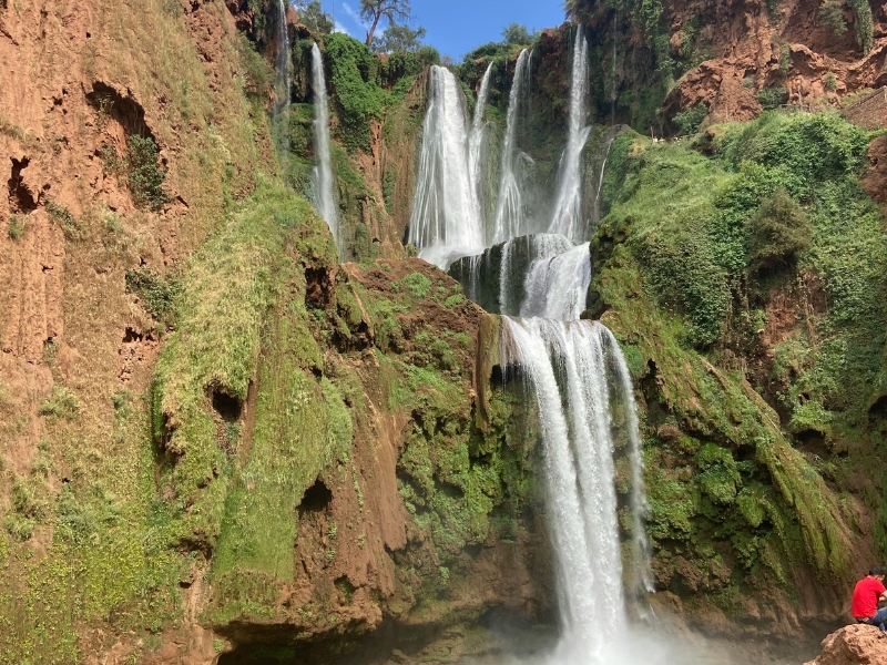 Ouzoud Waterfalls main cascade with rainbow and lush greenery